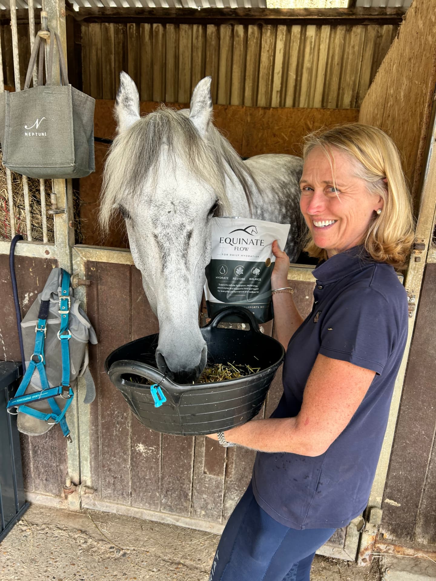 Customer feeding her grey horse with an Equinate Flow pouch