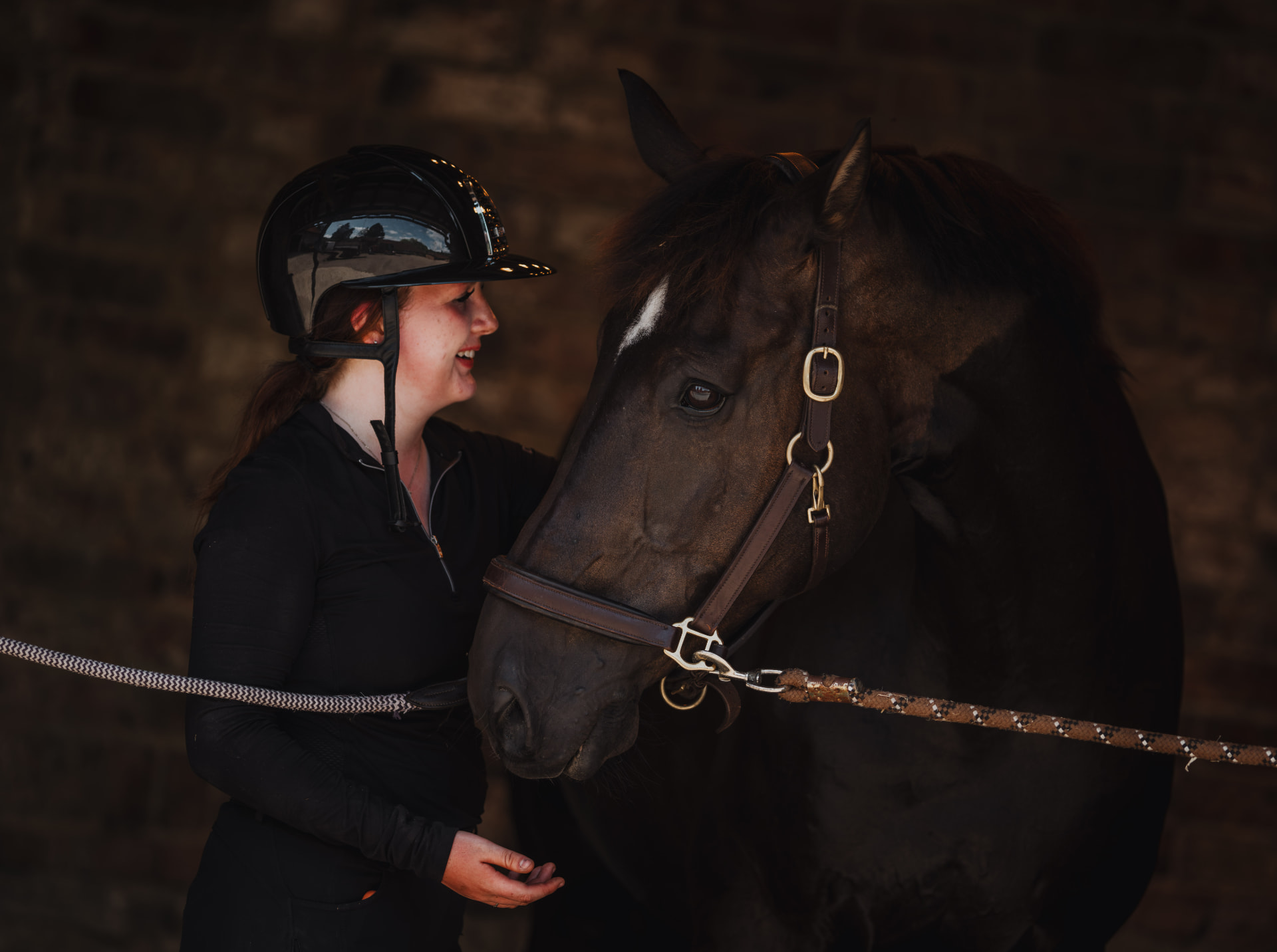 Customer with her horse in a dark stable portrait