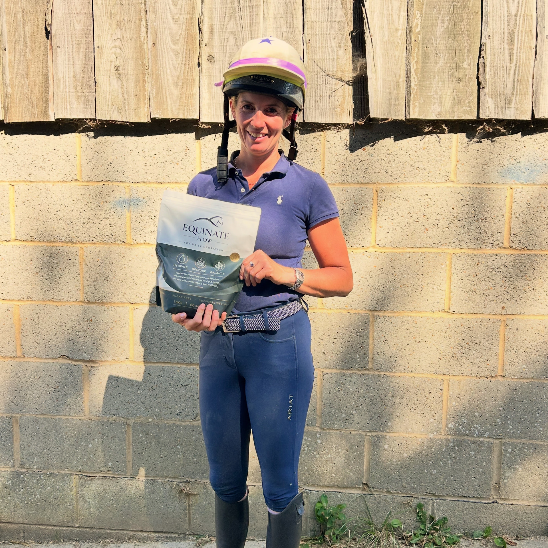 Customer holding an Equinate Flow pouch at the yard